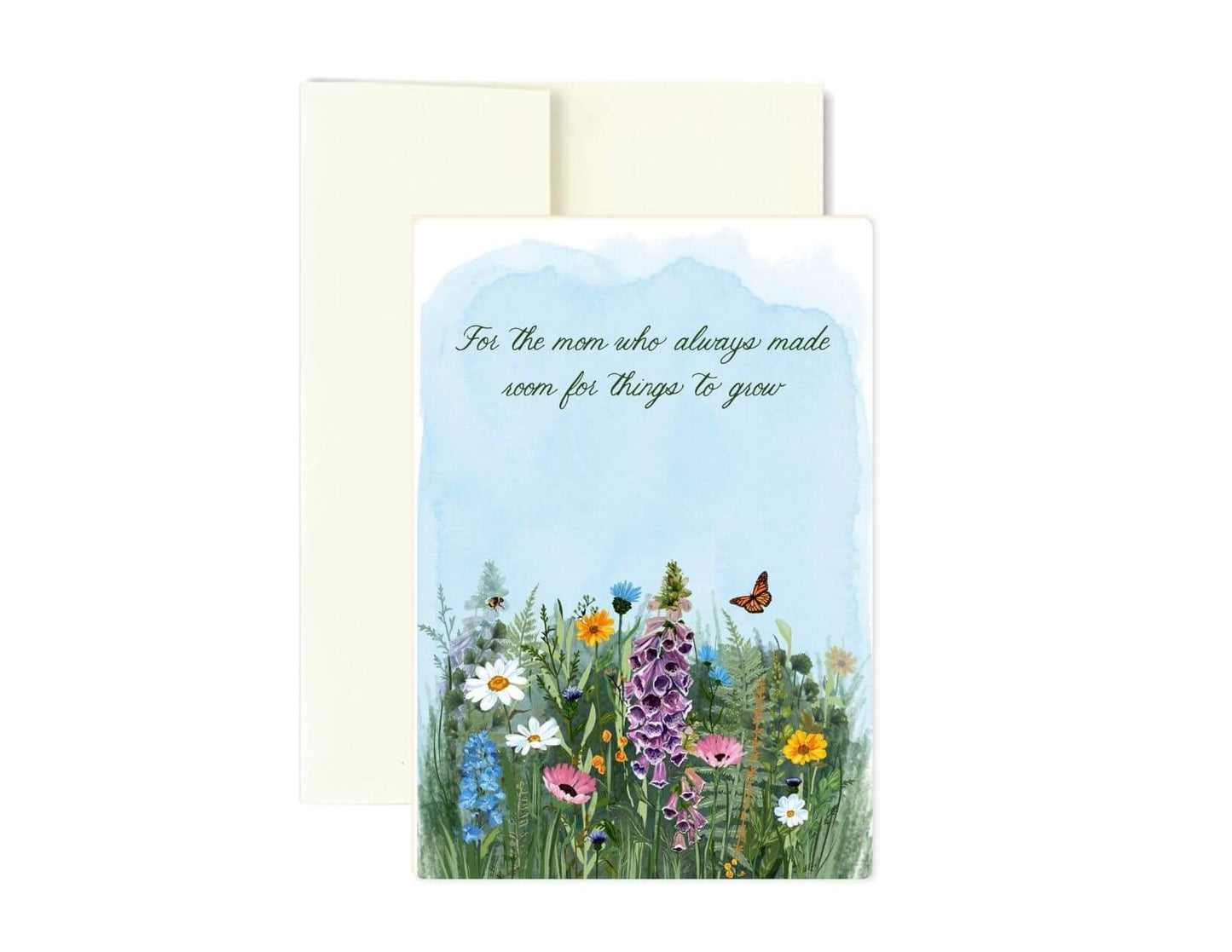 A floral greeting card with a watercolor-style wildflower meadow and a small butterfly, with the text 'For the mom who always made sure for things to grow,' shown with a cream envelope behind it on a white background.