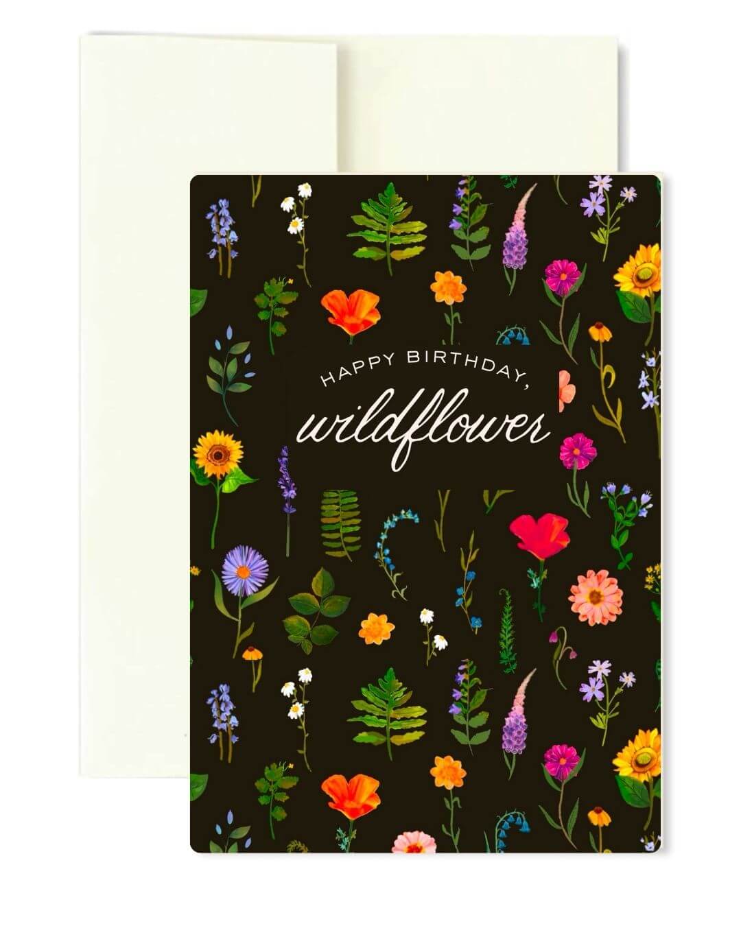 A birthday card with a dark brown background covered in colorful wildflower illustrations, with the words 'Happy Birthday, wildflower' in white script. An off-white envelope is partially visible behind the card on a white background.