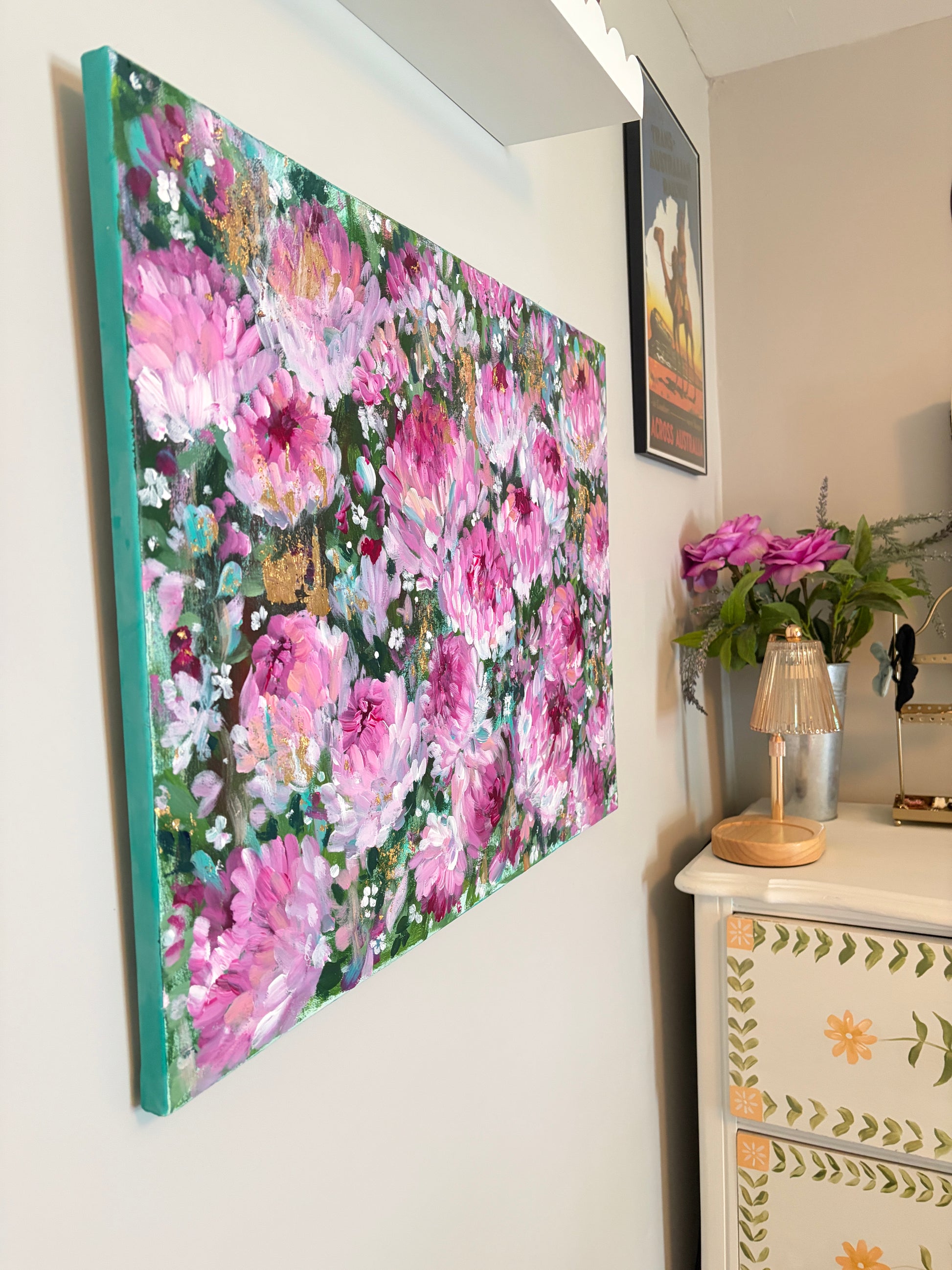 Floral painting on a wall with decorative items below