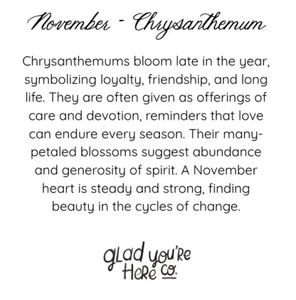 A text-based graphic with the heading 'November - Chrysanthemum' and a paragraph describing the symbolism of chrysanthemums in November. The text is black on a white background, with 'glad you're Here co.