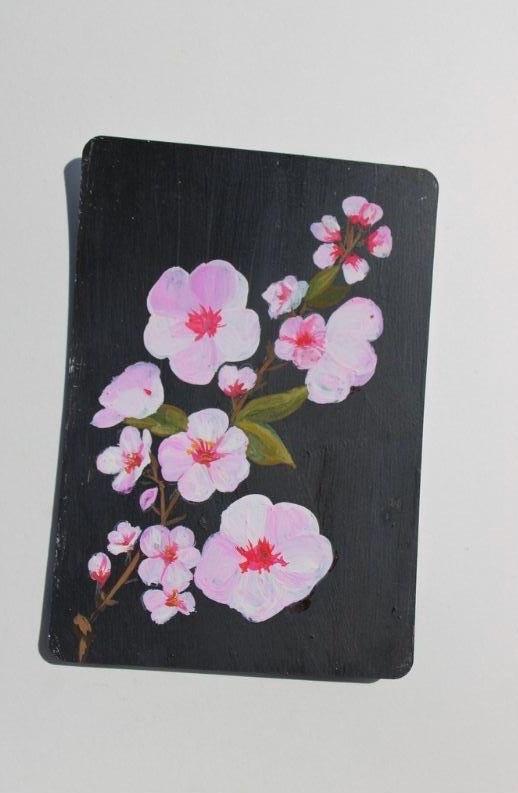Black notebook with pink floral design on a white background