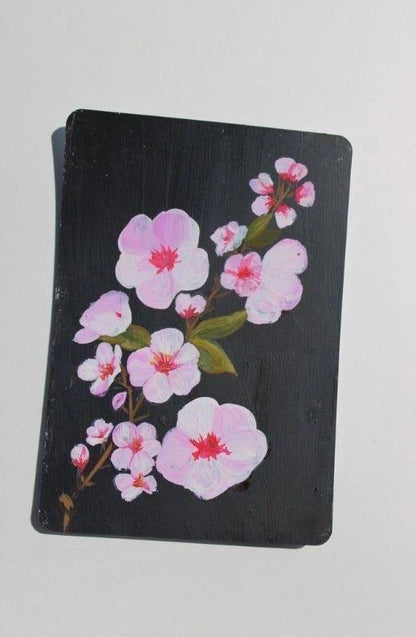 Black notebook with pink floral design on a white background