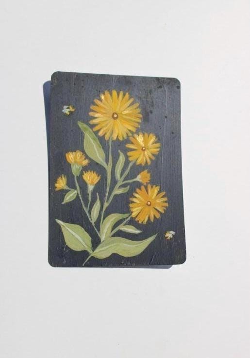 Card with yellow flowers and green leaves on a dark background