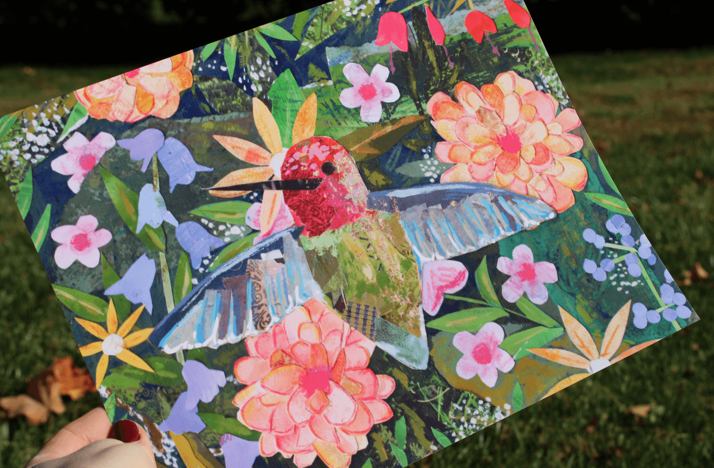 Colorful patchwork art piece with a hummingbird and flowers on a grassy background