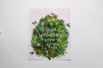Card with a green wreath and flowers on a pink background with text 'Give yourself room to grow'.