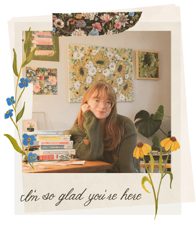 Person sitting at a desk with floral decorations and books, surrounded by flowers.