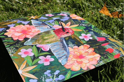 Colorful quilt with floral and butterfly design on grass