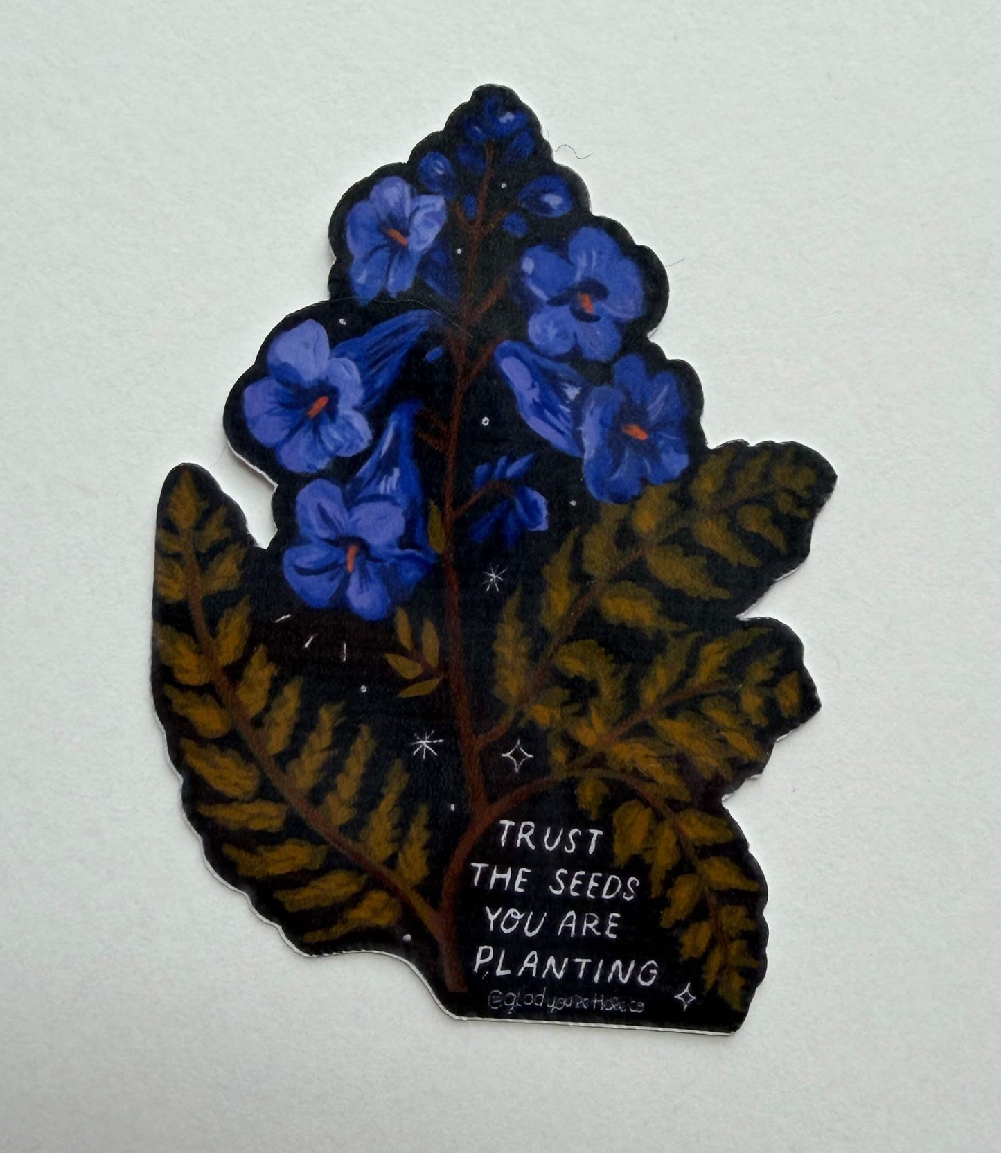 Decorative sticker with blue flowers and brown leaves on a white background