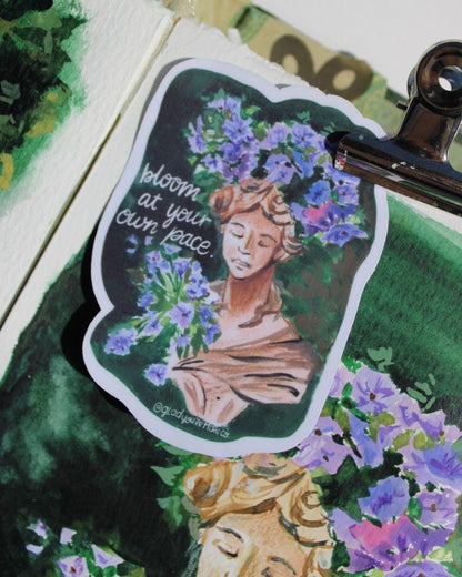 Sticker with a woman's face and floral design on a green background