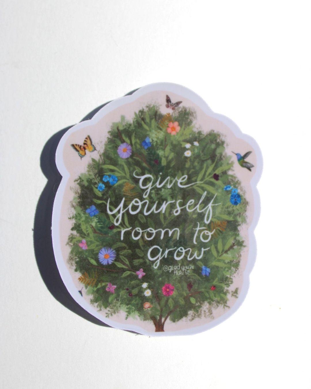 Decorative sticker with greenery, flowers, butterflies, and text 'Give yourself room to grow' on a white background.