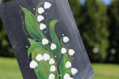 Painting of lilies of the valley on a dark background with green leaves and white flowers.