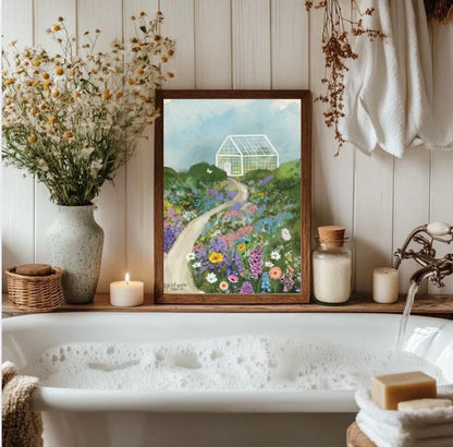 Bathroom with a bathtub, flowers, candles, and a framed painting of a garden.
