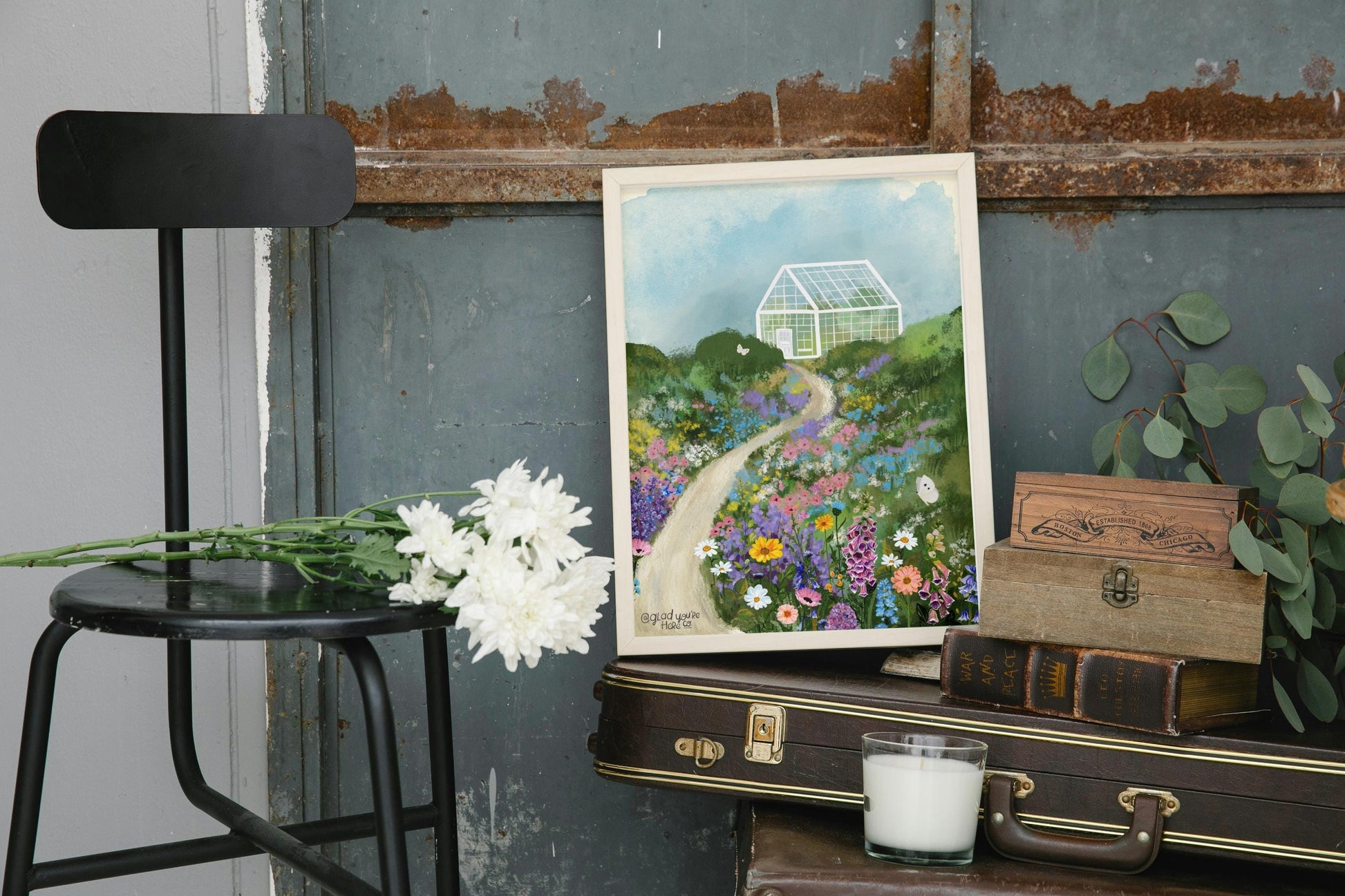 Art print of a garden scene on a rustic surface with a chair and flowers.