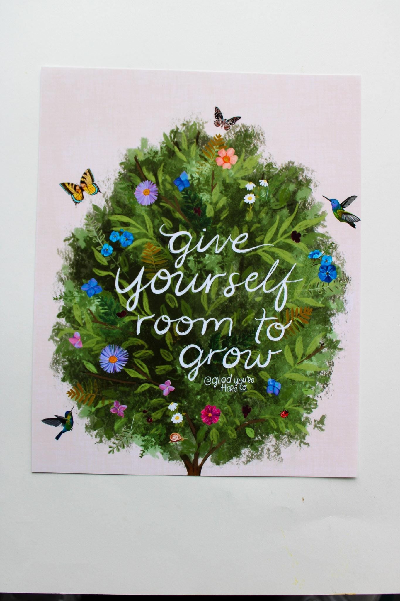 Poster with a green wreath, flowers, and butterflies on a pink background with text 'Give yourself room to grow'.