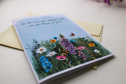 Greeting card with floral design and envelope on a white surface