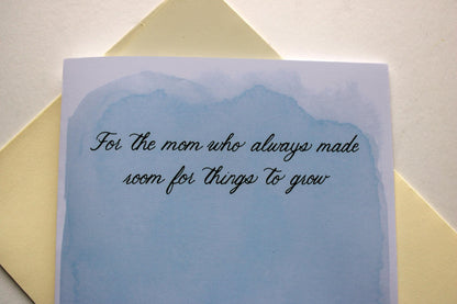 Greeting card with text on a light blue background, placed on a yellow envelope.