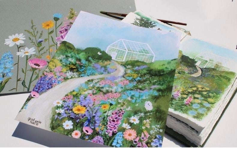 Gardening-themed greeting cards with floral designs and greenhouses on a white surface.