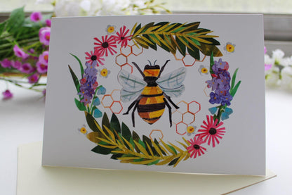 Greeting card with a bee and floral design on a white background