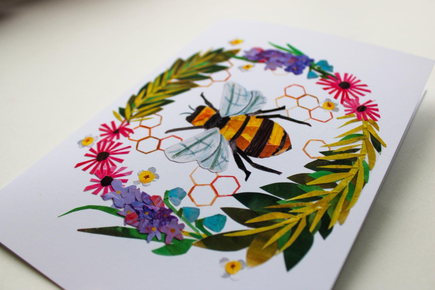 Greeting card with a bee and floral design on a white background