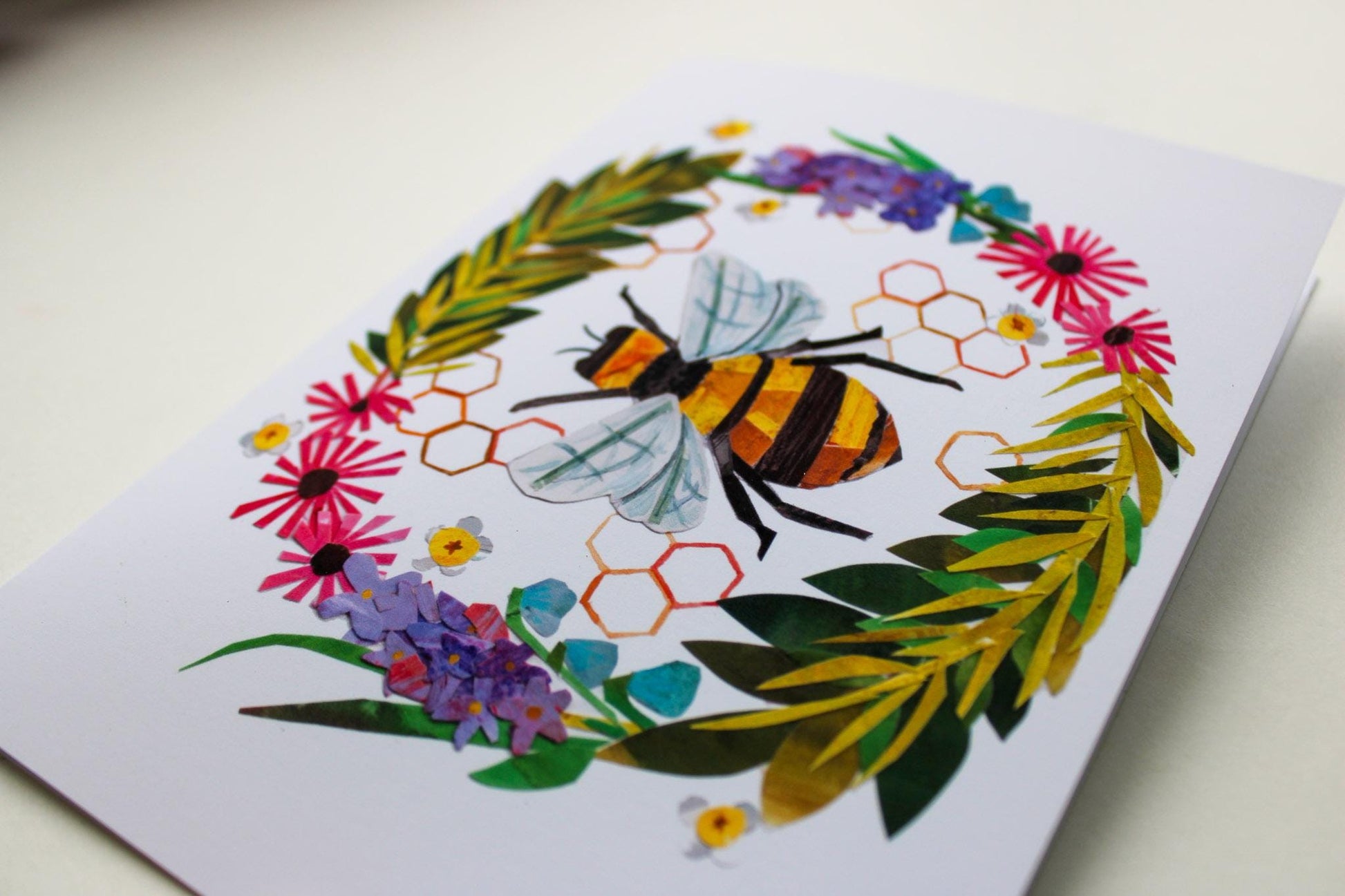 Greeting card with a bee and floral design on a white background