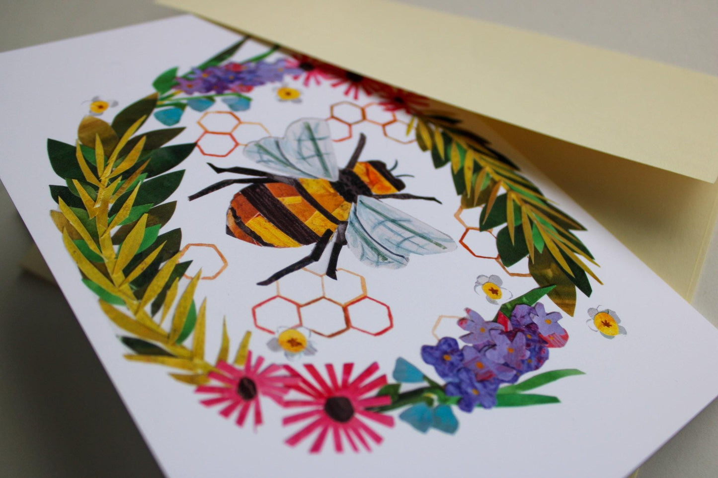 Greeting card with a bee and floral design on a white background