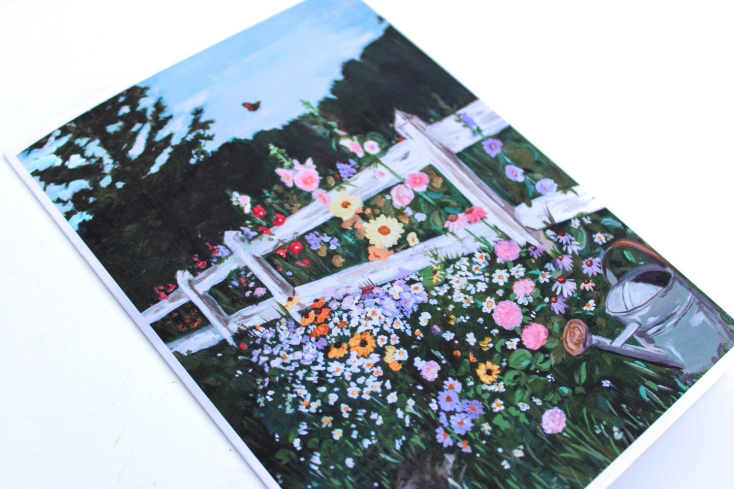 Notebook with a garden scene design featuring flowers and a white fence.