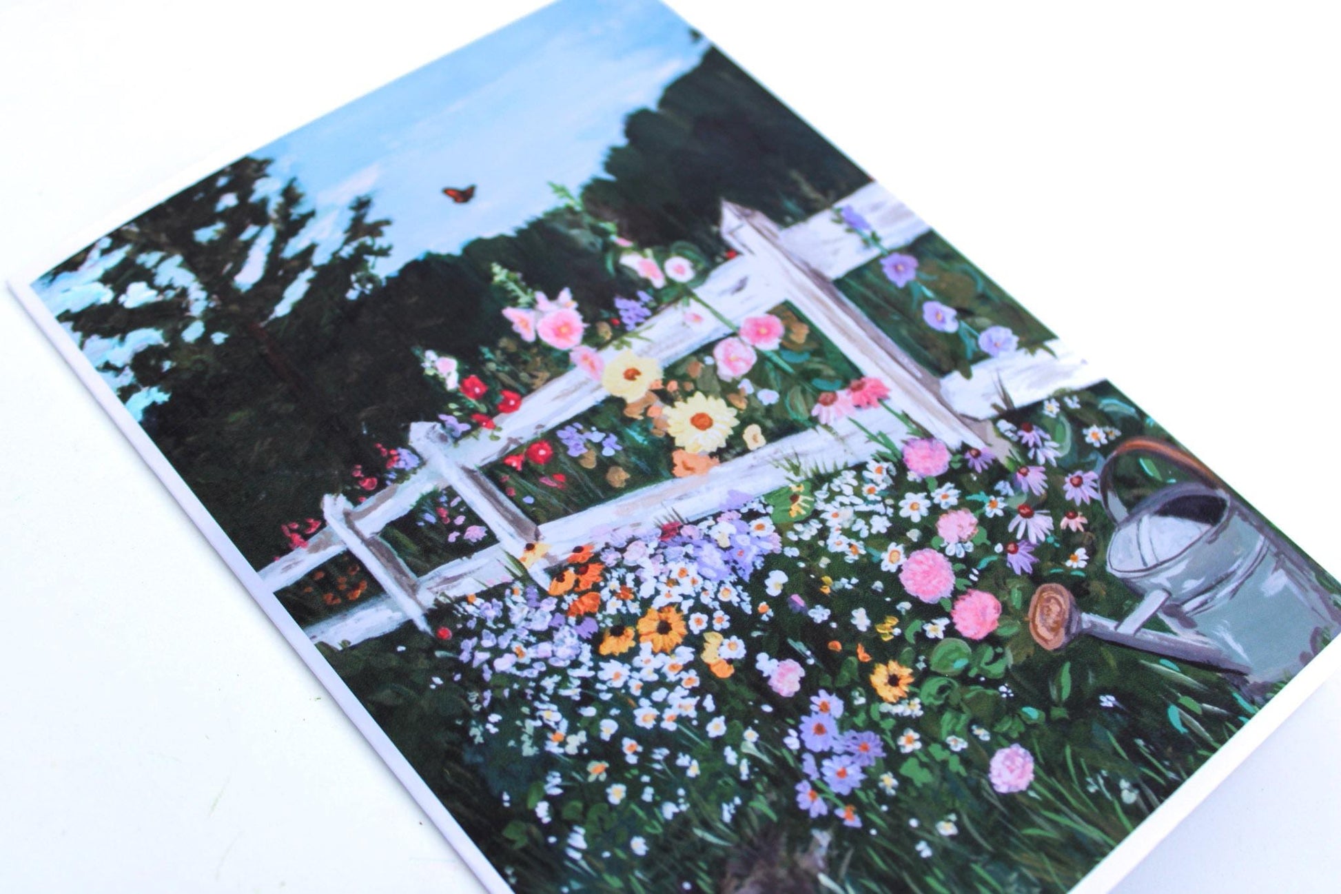 Notebook with a garden scene design featuring flowers and a white fence.