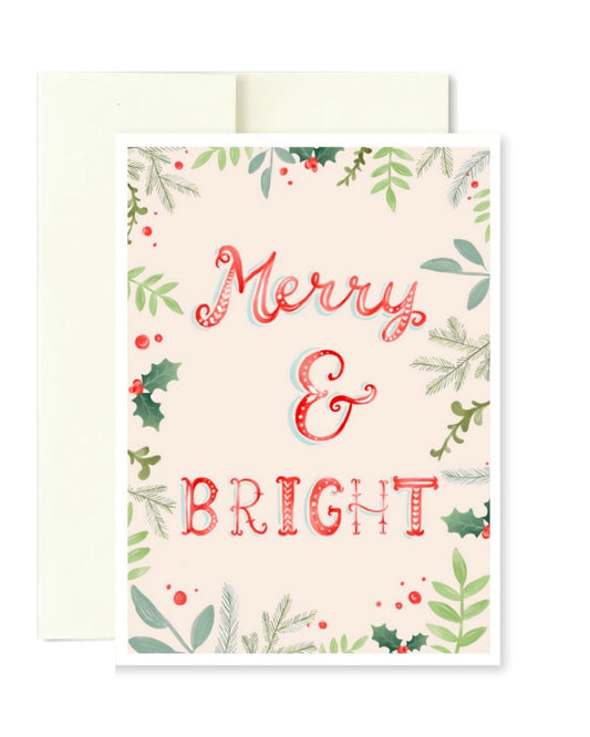 A festive holiday greeting card with a cream background, decorated with green foliage, red berries, and holly leaves, featuring the words 'Merry & BRIGHT' in red and white patterned lettering. A cream envelope is positioned behind the card.