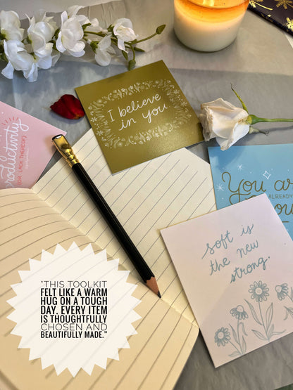 Notebook, cards, and pen on a surface with decorative elements