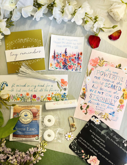 Collection of cards, a stress relief product, and decorative items on a surface with flowers.