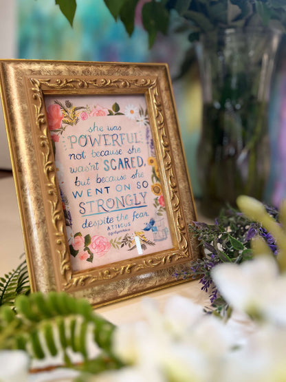 Decorative framed print with motivational quote surrounded by flowers and greenery