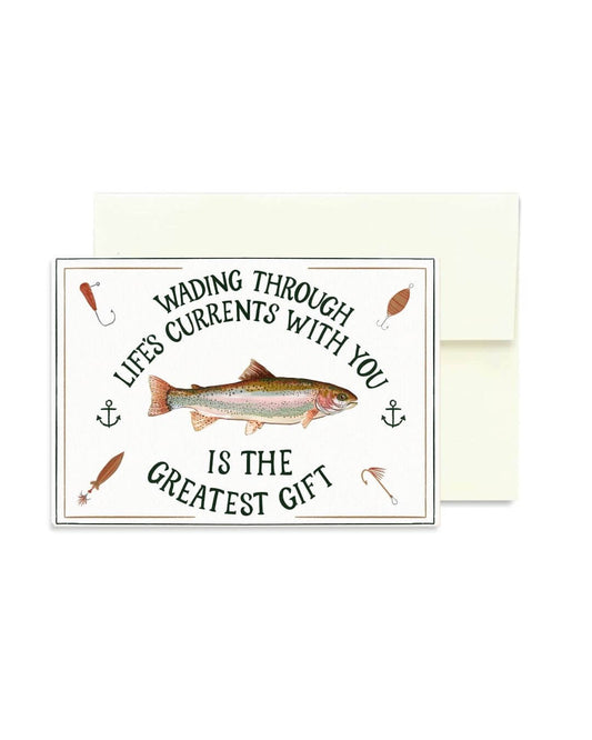 A square greeting card with a white envelope behind it, featuring a fish illustration and the text 'WADING THROUGH LIFE'S CURRENTS WITH YOU IS THE GREATEST GIFT'.